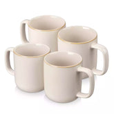 Playa 16oz stoneware mugs in beige reactive glaze on a rustic wooden café table with coffee maker and pastries