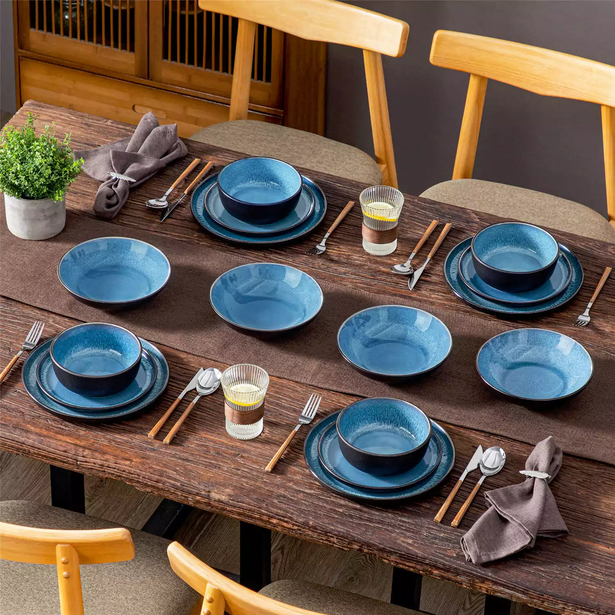 Playa 16-piece glossy dinnerware set for four on a rustic farmhouse table with Mediterranean-inspired glaze