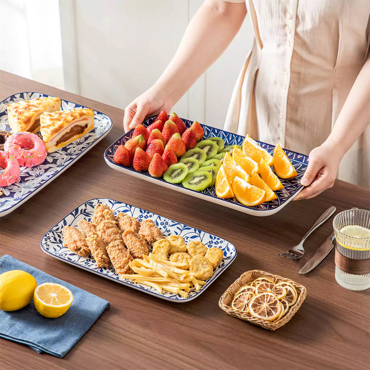 Selene indigo porcelain 3 piece serving platters set with snacks fruit donuts and bread on brown wooden table lemon.