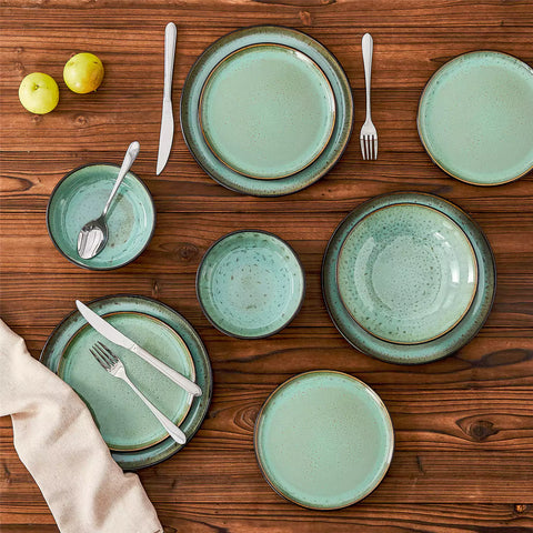Assorted dishes with soup - dessert - and fruit salad on rustic wooden table - Amber 16-Piece green stoneware dinnerware set with plates and bowls by vancasso