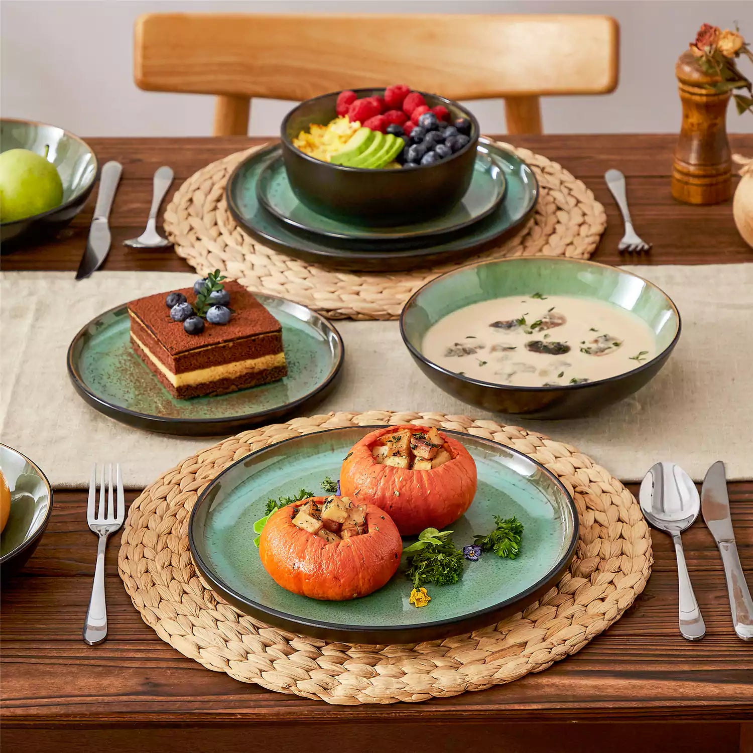 Assorted dishes with soup - dessert - and fruit salad on rustic wooden table - Amber 16-Piece green stoneware dinnerware set with plates and bowls by vancasso