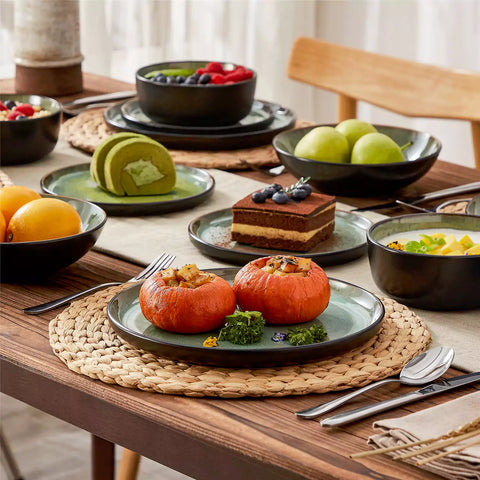 Assorted dishes with soup - dessert - and fruit salad on rustic wooden table - Amber 16-Piece green stoneware dinnerware set with plates and bowls by vancasso
