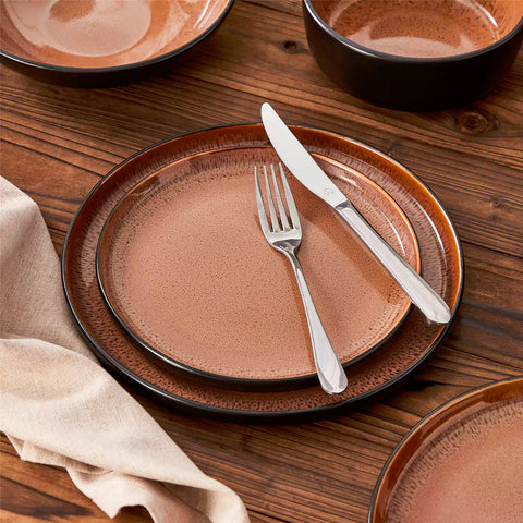 Assorted dishes with soup - dessert - and fruit salad on rustic wooden table - Amber 16-Piece red stoneware dinnerware set with plates and bowls by vancasso
