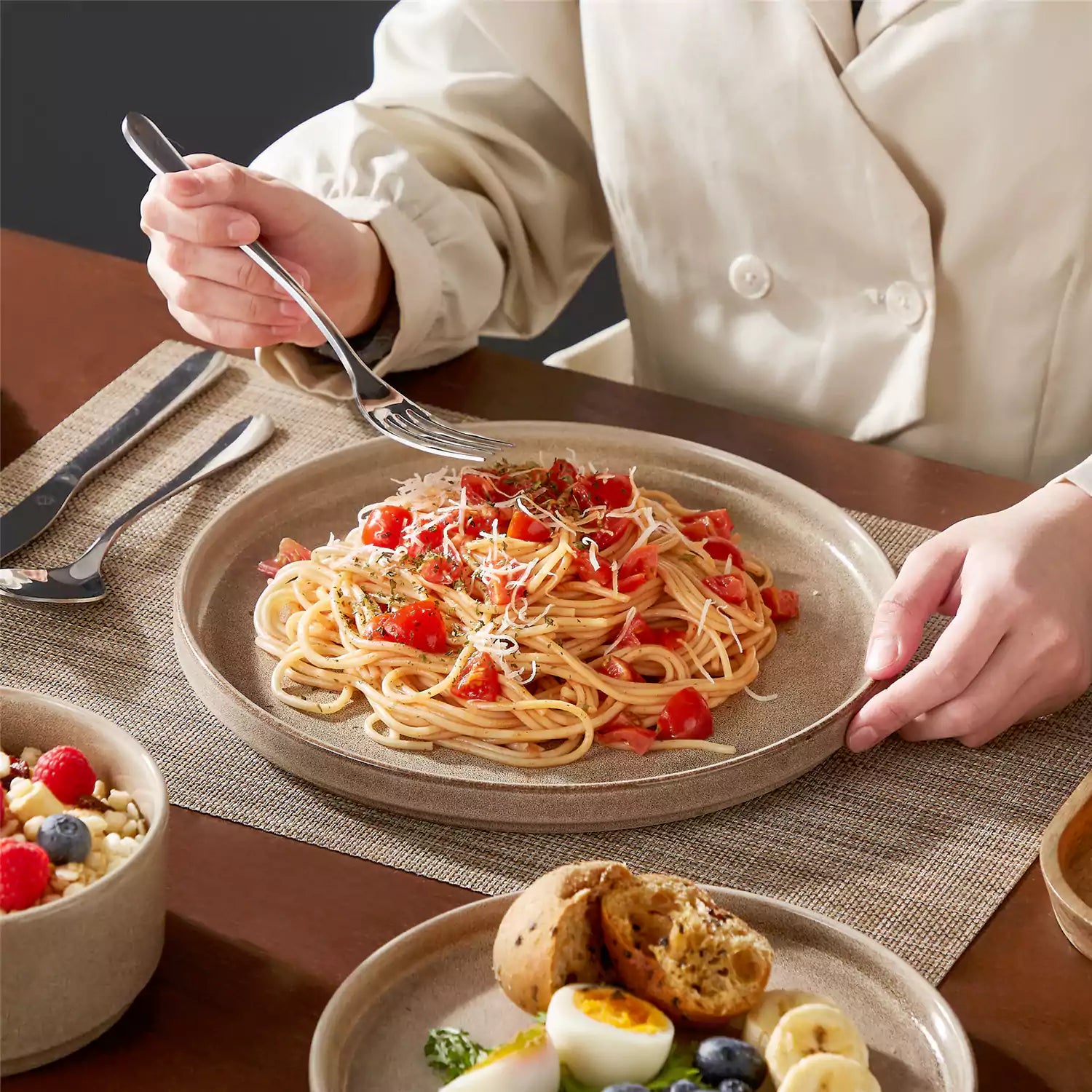 Anya 12 piece straight edge stoneware dinner set in caramel with food on a rustic farmhouse wooden table with a side salad and cutlery