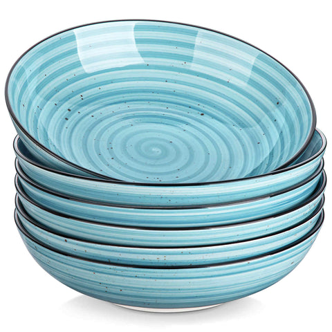 Bonbon double-sided stoneware pasta bowls in blue - artfully filled with pasta - fresh fruit salad - pumpkin soup - and oatmeal - exuding rustic charm on a white dining table