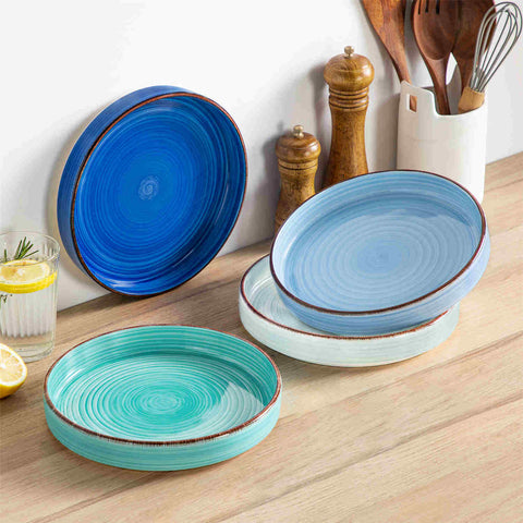 Bonita straight-edge pasta bowls set of 4 on a white table - filled with spaghetti - fruit salad - and mango - accompanied by a small honey jar - ibrant stoneware in ocean blues