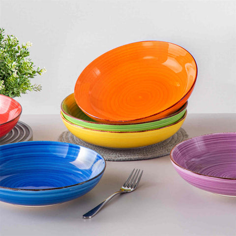 Multicolor Bonita large stoneware bowls set of 6 on a white table - each filled with pasta - pumpkin soup - and fruit salad - creating a bright and inviting table setting