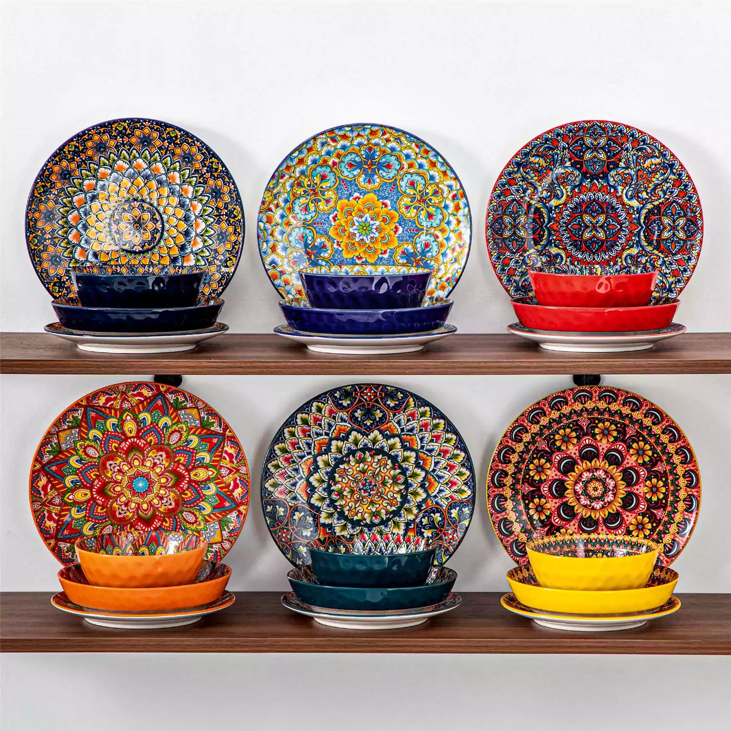 Lumi 24 piece porcelain dinnerware set with vibrant patterns stacked on a wooden table with colorful placemats and assorted dishes