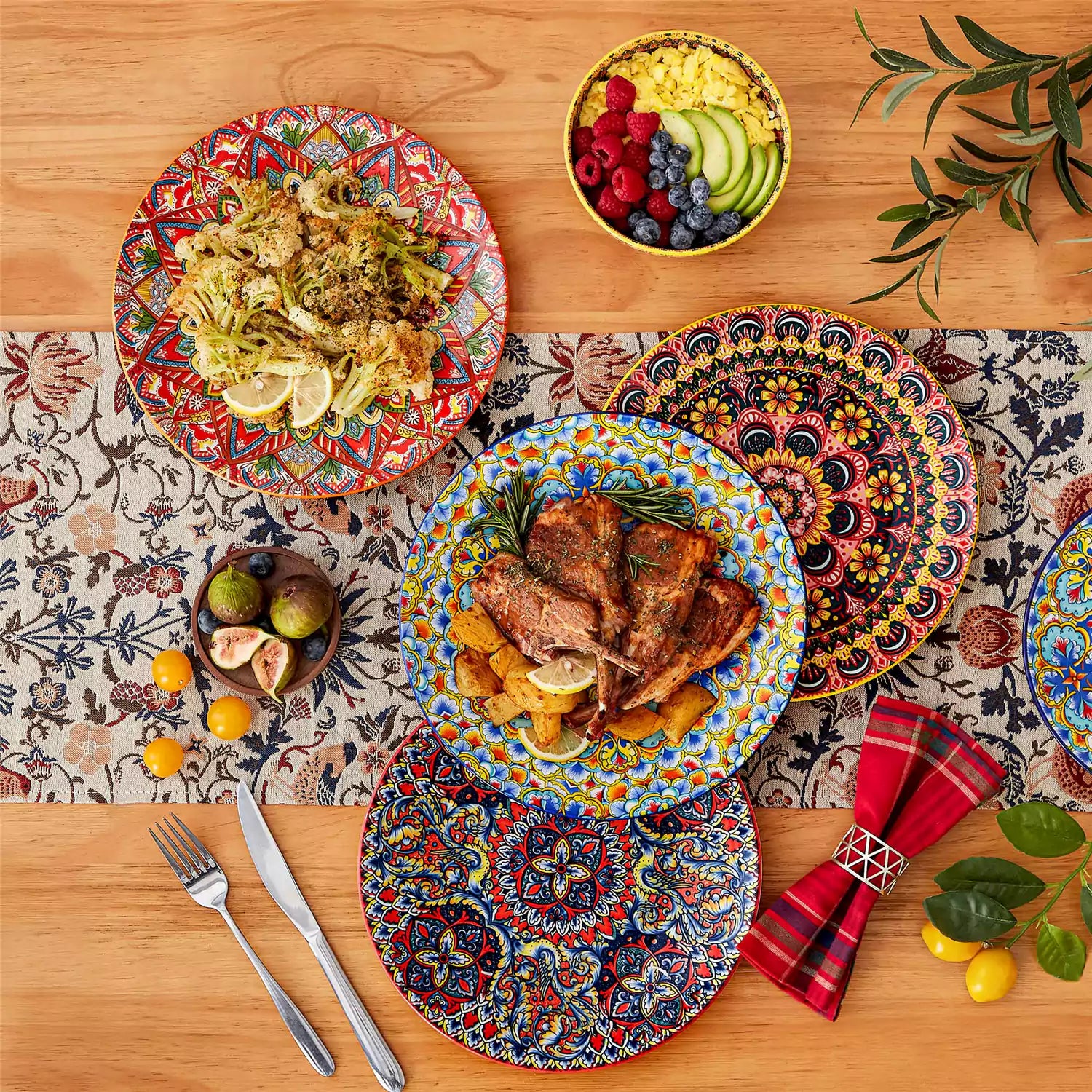 Lumi 12-piece Bohemian dinnerware set for 4 with colorful patterned plates and bowls on a wooden Boho dining table with food