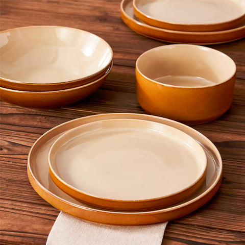 Assorted family dinnerware on wooden table brown stoneware soup bowl pasta with shrimp fruit tart and bread perfect for everyday meals