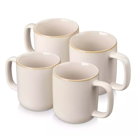 Playa 16oz stoneware mugs in beige reactive glaze on a rustic wooden café table with coffee maker and pastries