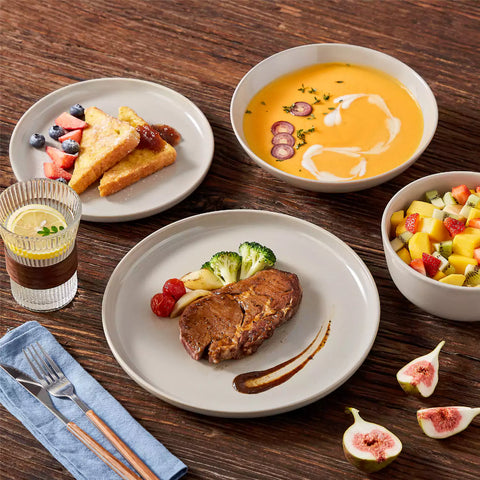 A glossy grey 16-piece stoneware dinnerware set from the Playa collection - featuring farmhouse charm with plates and bowls for 4 people-vancasso