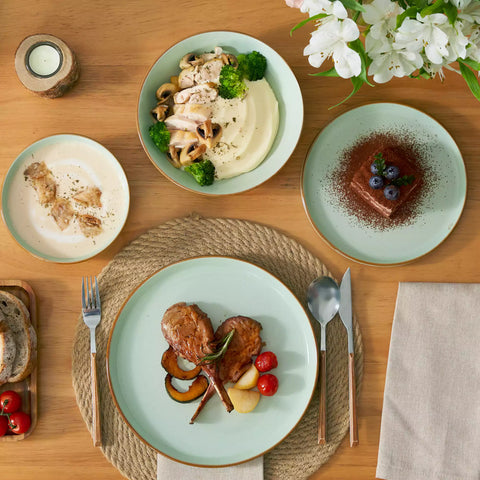 Rustic green speckled stoneware dinnerware set with lipped-edge plates and bowls arranged on a sunlit modern dining table-vancasso