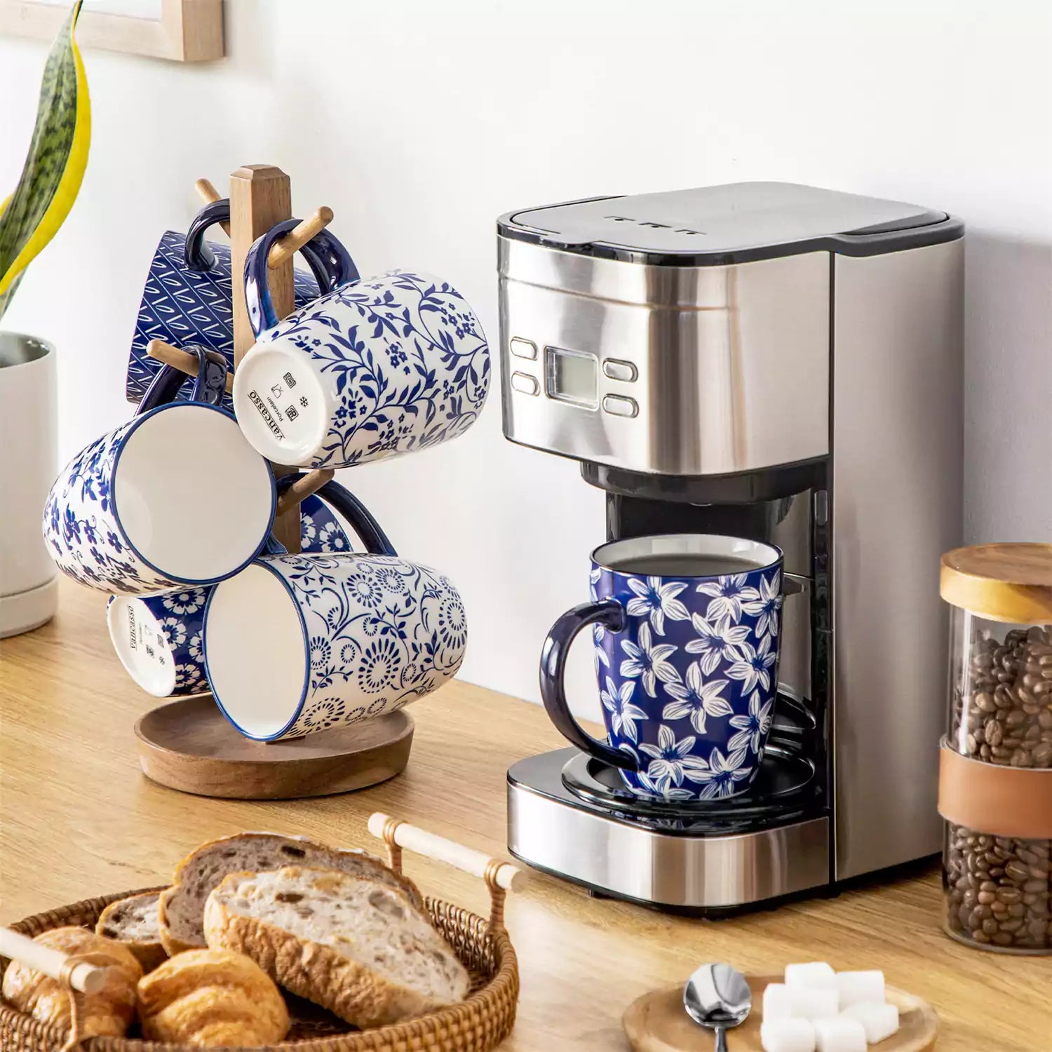 Set of six Japanese-style stoneware mugs in blue and white with indigo patterns, displayed on a kitchen counter with scattered coffee beans