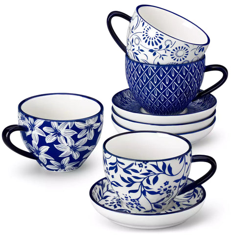 Set of 4 Selene indigo floral porcelain cups and saucers on a wooden table with coffee and pastries featuring blue and white Japanese style mix and match patterns