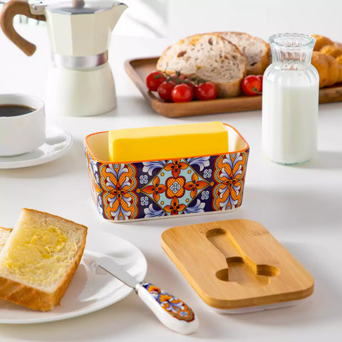 Bold orange porcelain butter dish with wooden lid in boho chic style - perfect for a colorful breakfast table with bread and coffee-vancasso