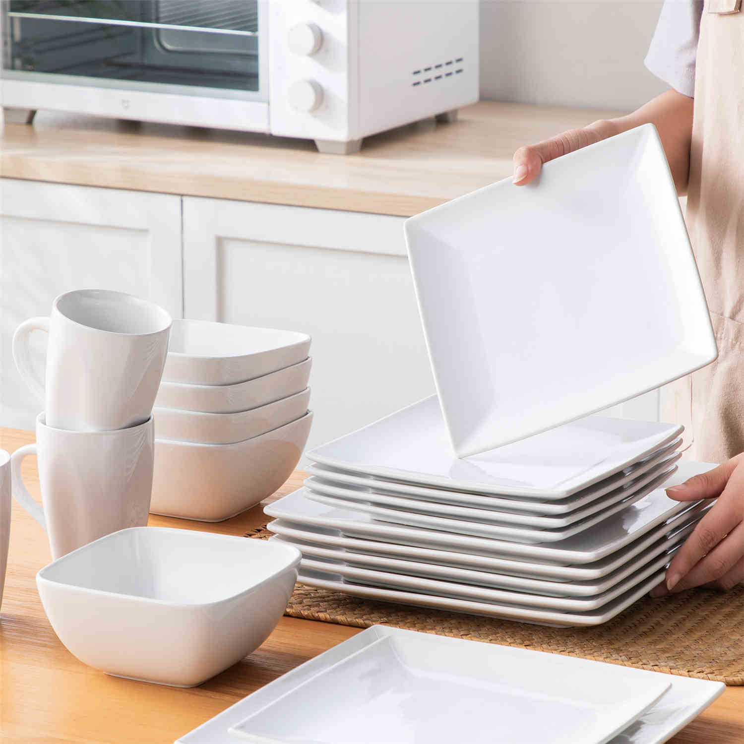 A glossy white 24-piece stoneware dinnerware set from the Soho collection - featuring a sleek square design with plates and mugs for 6 people-vancasso