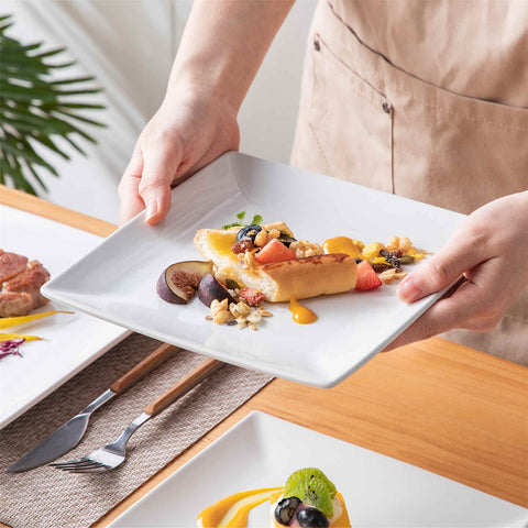 A glossy white 24-piece stoneware dinnerware set from the Soho collection - featuring a sleek square design with plates and mugs for 6 people-vancasso