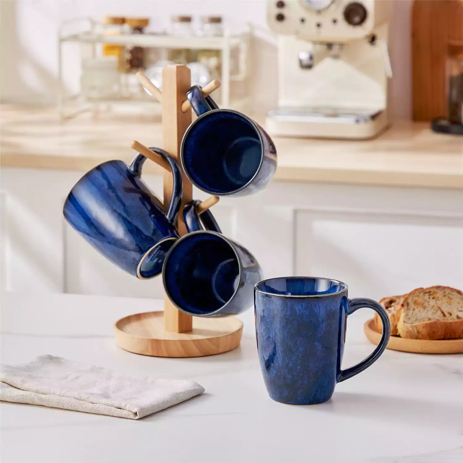 Set of 4 Starry 16oz stoneware mugs in blue with reactive glaze finish styled on a marble countertop with fresh coffee