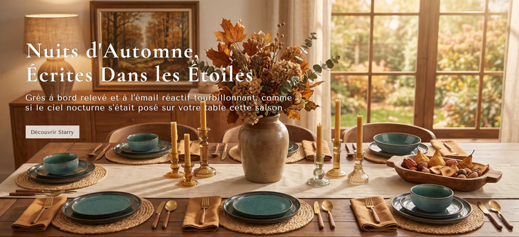 Une table à manger sur le thème de l'automne, dressée dans une pièce chaleureuse et baignée de lumière. La table est décorée de bols en céramique bleu-vert, de couverts dorés, de sets de table tressés et d'un grand vase central rempli de feuillage automnal.