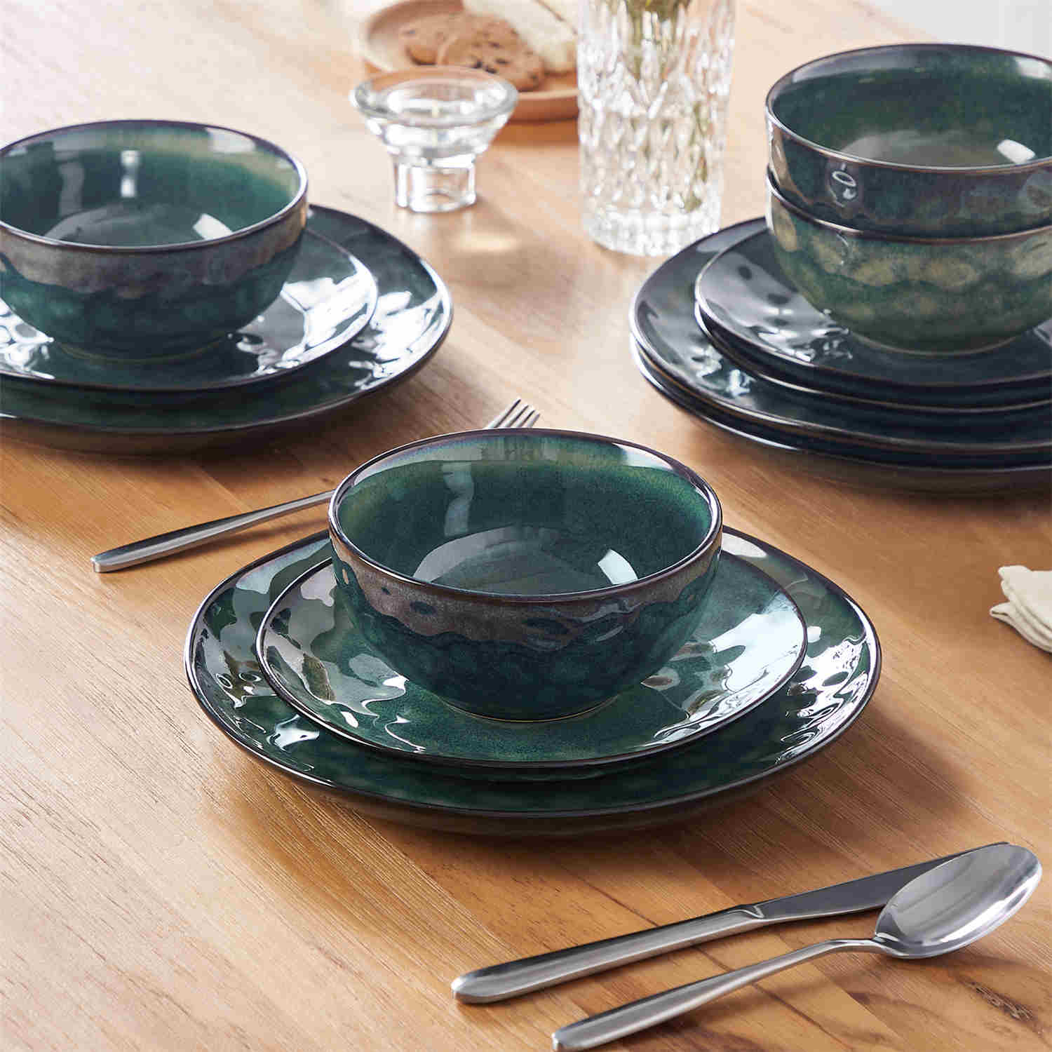 Starry 12-piece stoneware dinnerware set in green on a light wooden table - styled with lamb chops - pastries - coffee pot - and lemon water for a cozy farmhouse breakfast scene