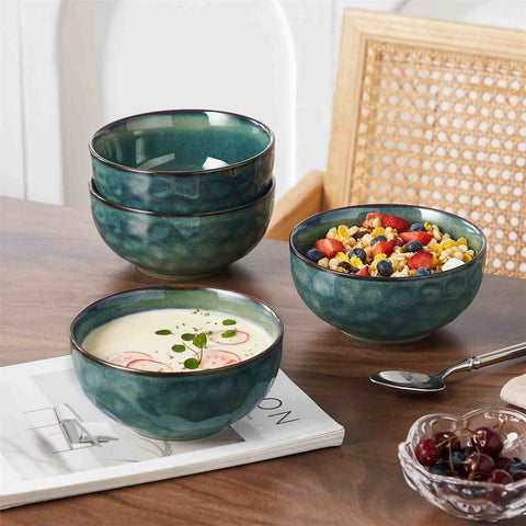 Starry reactive glaze cereal bowls in teal green on a rustic wooden table - filled with creamy soup - pasta - and fresh fruit salad for a cozy - celestial dining vibe